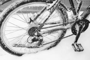 Fahrradrad in Schnee und Eis bei kaltem Winterwetter Nahaufnahme foto