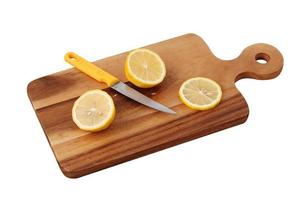 Zitrone und Messer auf Holztablett auf weißem Hintergrund foto