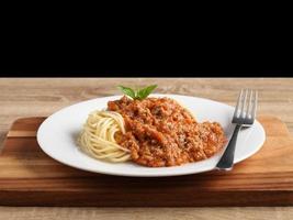 Nahaufnahme einer Gabel mit Spaghetti und roter Soße in weißer Schale foto