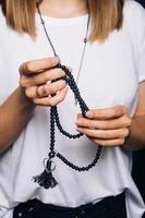 schwarzes Perlenarmband in Mädchenhand foto