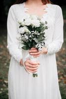 Hochzeitsstrauß aus Rosenblüten in den Händen der Braut foto