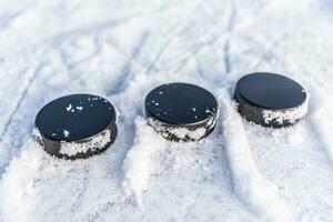 schwarz Eishockey Pucks Lügen auf Eis beim Stadion foto