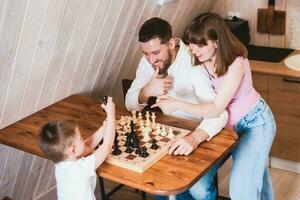 schwanger Mama Aufpassen Papa und Sohn abspielen Schach beim das Tabelle foto