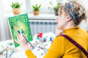 lockig blond Frau Gemälde ein Bild durch das Fenster foto