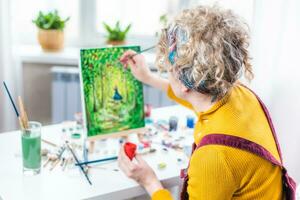 lockig blond Frau Gemälde ein Bild durch das Fenster foto