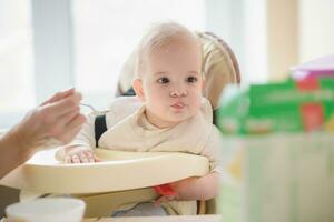 Mama Einspeisungen ihr neun Monate Baby beim Zuhause foto