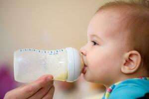 Mutter Einspeisungen Baby von ein Flasche von Milch foto