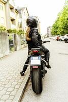 Mitte alt Frau im Motorradfahrer Kleidung Reiten ein modern Motorrad draußen foto