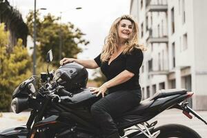 Mitte alt Frau im Motorradfahrer Kleidung Reiten ein modern Motorrad draußen foto