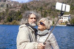 schön reifen Paar nimmt ein Selfie auf das Dock foto