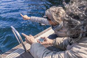 schön reifen Paar Sitzung auf das Dock sieht aus beim Kompass foto