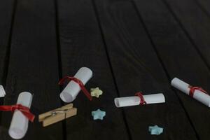 eben legen romantisch Hintergrund. Geschenkbox, gerollt Wunsch Papiere, und hölzern Rahmen mit Papier Herzen auf dunkel Holz Tafel. foto