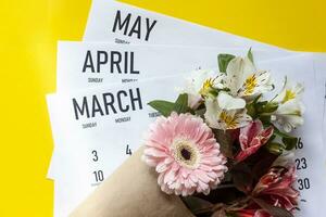 Frühling Monate Kalender mit ein Frühling Blume Strauß foto