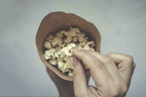 ein Papier Kegel voll von Popcorn auf das Marmor foto