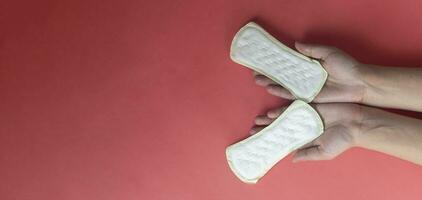 Frau Hände halten zwei feminin Hygiene Pads. Hände von weiblich halt Menstruation- Pads oder sanitär Servietten zum Frauen foto