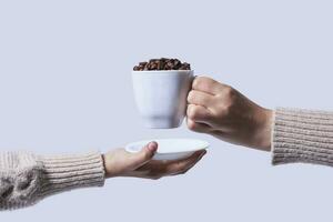 Hand halt Tasse voll von roh Kaffee Bohnen foto