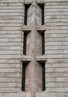 lange eng Fenster im ungewöhnlich Winkel auf Beige Stein Mauer foto