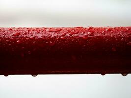 rot Metall Geländer im das Regen - - Tröpfchen von Wasser foto