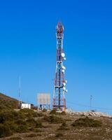 groß rot und Weiß Antenne Turm auf oben von das Berg foto