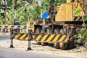 groß Maschine LKW mit Barriere Schutz reparieren das Straße im Konstruktion Seite? ˅ foto