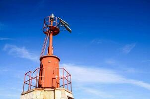 ein rot Leuchtturm gegen ein Blau Himmel foto