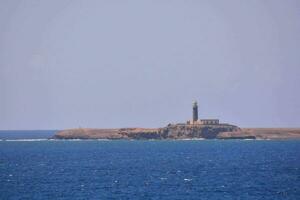 ein Leuchtturm auf ein Insel im das Mitte von das Ozean foto
