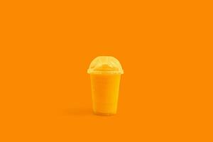 frisch Orange Saft Smoothie im Plastik Tassen nehmen Weg auf Hintergrund, Obst trinken zum gesund Konzept foto