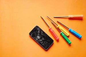 Draufsicht des gebrochenen Smartphones auf Farbhintergrund foto