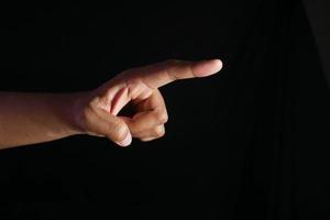 Mann Hand zeigt mit dem Finger isoliert auf schwarz foto