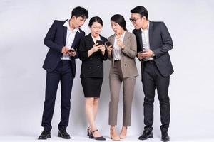 Gruppe asiatischer Geschäftsleute posiert auf weißem Hintergrund