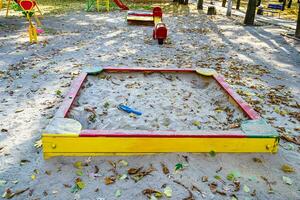 Fotografie zum Thema leerer Sandkasten aus Holz mit Sand für Kinder foto