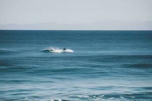 Surfer auf Blau Ozean Welle bekommen Fass beim Sonnenaufgang. neural Netzwerk ai generiert foto