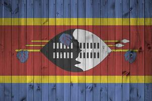 Swasiland Flagge abgebildet im hell Farbe Farben auf alt hölzern Mauer. texturiert Banner auf Rau Hintergrund foto