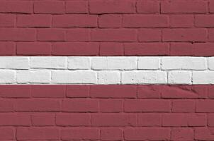 Lettland Flagge abgebildet im Farbe Farben auf alt Backstein Mauer. texturiert Banner auf groß Backstein Mauer Mauerwerk Hintergrund foto