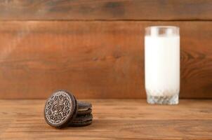 viele Oreo Sandwich Sahne Kekse und Milch Glas auf hölzern Hintergrund foto