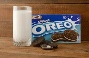 viele Oreo Sandwich Sahne Kekse mit Pack und Milch Glas auf hölzern Hintergrund foto