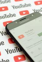 Youtube App auf Samsung Smartphone Bildschirm auf Papier Banner mit klein Youtube Logos und Inschriften. Youtube ist Google Tochtergesellschaft und amerikanisch die meisten Beliebt Video teilen Plattform foto