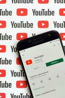 Youtube App auf Samsung Smartphone Bildschirm auf Papier Banner mit klein Youtube Logos und Inschriften. Youtube ist Google Tochtergesellschaft und amerikanisch die meisten Beliebt Video teilen Plattform foto