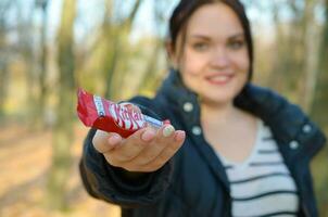 Charkow, Ukraine - - Oktober 21, 2019 jung Mädchen geht vorbei ein Kit kat Schokolade Bar im ein Herbst Park. das Manifestation von Freundlichkeit, Behandlung mit Süßigkeiten foto