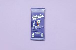 Milka Schokolade Tablette im klassisch violett Verpackung auf lila Hintergrund. Milka ist Marke von Schokolade Konfekt entstanden im Schweiz im 1901 foto