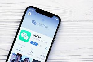Charkow, Ukraine - - März 5, 2021 wechat Bote Symbol und Anwendung von App Geschäft auf iPhone 12 Profi Anzeige Bildschirm auf Weiß Tabelle foto
