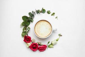 weiße Kaffeetasse mit frischen Blumen Kreis auf weißem Hintergrund foto