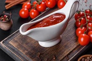 rote Soße oder Ketchup in einer Schüssel und Zutaten zum Kochen foto