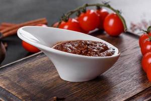 rote Soße oder Ketchup in einer Schüssel und Zutaten zum Kochen foto