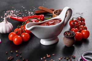 rote Soße oder Ketchup in einer Schüssel und Zutaten zum Kochen foto