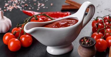 rote Soße oder Ketchup in einer Schüssel und Zutaten zum Kochen foto