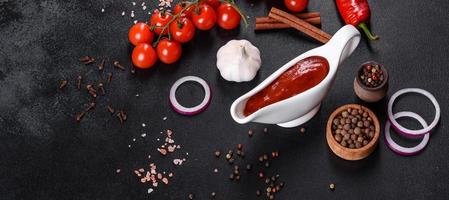 rote Soße oder Ketchup in einer Schüssel und Zutaten zum Kochen foto