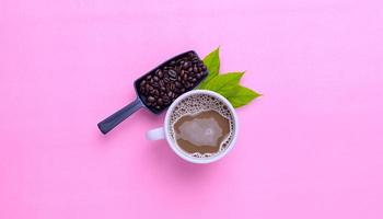 Kaffeetasse und Kaffeebohnen auf rosa Hintergrund foto