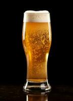 ein Glas von kalt frisch Bier mit Deckel von Schaum. Spritzen von Schaum mit lecker amerikanisch Bier. Bier Tag Konzept durch ai generiert foto