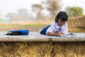 asiatischer Student in Uniform, der in der Landschaft von Thailand studiert foto